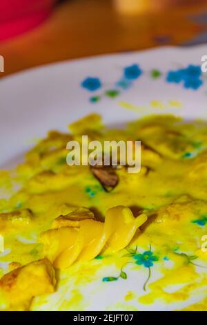 Motte in Food Curry Sauce mit Pasta auf dem Teller. Insekt in der Nahrung. Stockfoto