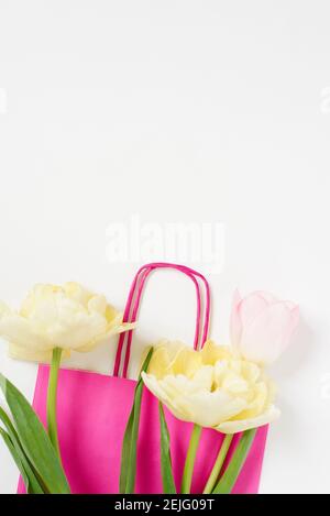 Ein Bouquet von schönen Tulpen und eine Packung auf einem hellen Hintergrund Draufsicht mit Kopierraum. Muttertag Hintergrund, Internationaler Frauentag. Urlaub, Stockfoto