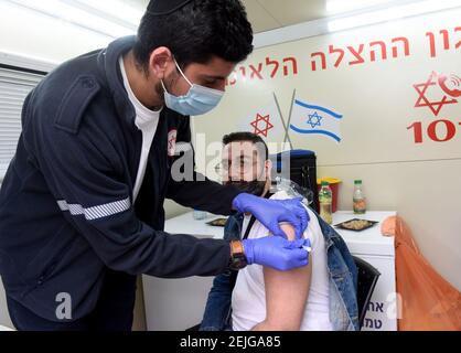 Jerusalem, Israel. Februar 2021, 22nd. Ein Sanitäter mit Magen David Adom, Israels nationaler Notfallorganisation, gibt einem Mann den Pfizer-Biotech-Coronavirus-Impfstoff in einer mobilen Klinik in Jerusalems. Mahane Yehuda Markt, am Montag, 22. Februar 2021. Foto von Debbie Hill/UPI Kredit: UPI/Alamy Live Nachrichten Stockfoto