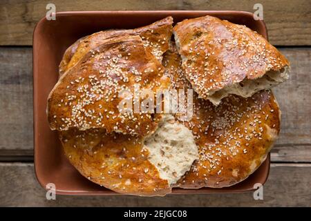 Hausgemachtes türkisches Pide-Brot, das mit Eigelb und Sesam glasiert wurde, auf einem hölzernen Hintergrund. England GB Stockfoto