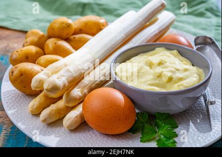 Zutaten für vegetarisches Frühlingsabendessen, hochwertiger holländisch weißer Spargel, gewaschen und an Bord geschält, bereit zum Kochen Stockfoto