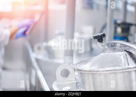 Edelstahltanks für die Lagerung von Milch, Frau Arbeiter prüft Qualität mit Tablet-Computer, Milchproduktion. Stockfoto