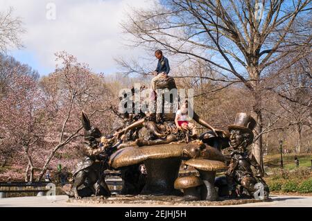 Kinder spielen auf der Bronzeskulptur Alice im Wunderland von José de Creeft im Central Park, NYC, New York, Amerika, USA Stockfoto