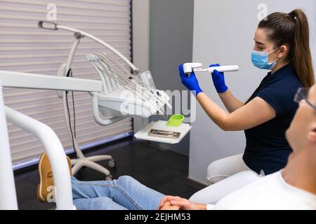 Der Zahnarzt Hygienist am Beispiel des künstlichen Kiefers zeigt wie Um Ihre Zähne mit einer elektrischen Bürste richtig zu putzen Stockfoto