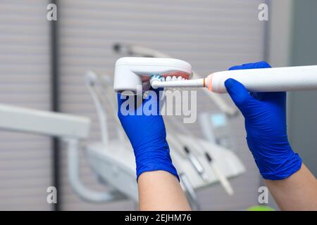 Zahnarzt zeigt, wie man Zähne mit elektrischer Bürste putzt. Konzept der Zahnhygiene Stockfoto