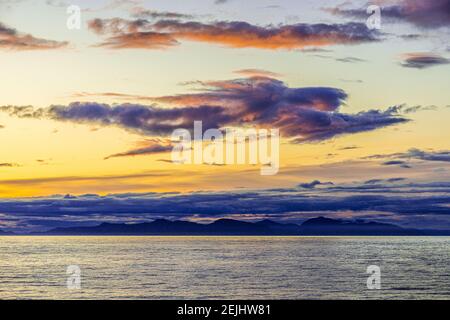 Seltsame Gestalt einer fliegenden Figur oder eines Engels bei Sonnenuntergang über der nordwestlichen Pazifikküste bei Prince of Wales Island, Alaska, USA - von einem Kreuzfahrtschiff aus gesehen. Stockfoto