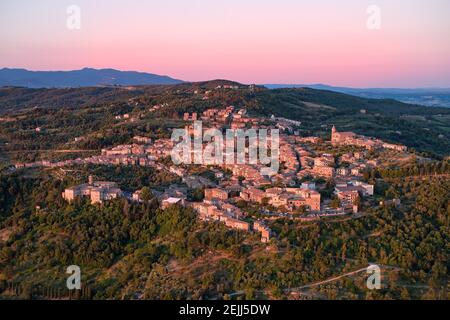 Luftaufnahme einer Stadt von Montalcino, beleuchtet von rosa Sonnenaufgang. Antike Stadt auf hügeliger Landschaft einer typischen toskanischen Landschaft. Orcia valle Stockfoto