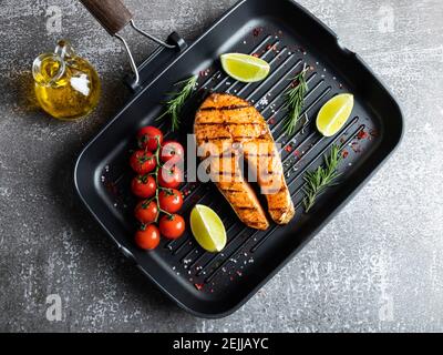 Gegrillter Steak Fisch Lachs, Forelle in einer Grillpfanne, würzig, Tomate, Nahaufnahme, Draufsicht Stockfoto