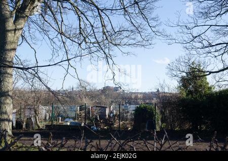 Gartenanlagen im Stadtzentrum mit Blick auf das Edinburgh Castle Und Frau beim Graben Stockfoto