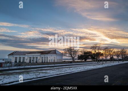 Das Bootstouren Pool Gebäude auf der öffentlichen Baum gesäumt Royal Esplanade an einem Wintertag mit Schnee auf dem Boden bei Sonnenuntergang. Stockfoto