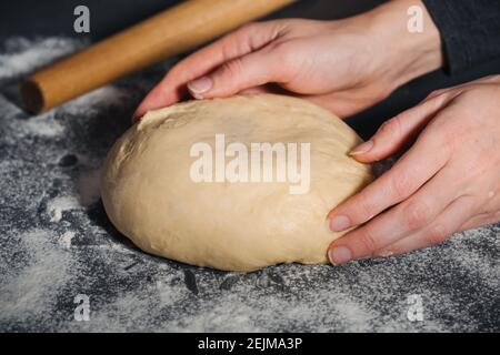 Frau, die handgemachten Teig für leckeres Brot auf Stein Tisch Hintergrund. Nahaufnahme Stockfoto