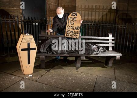 Glasgow, Schottland, Großbritannien. Februar 2021, 22nd. Im Bild: Sean Clerkin - Scottish Pächters Organization, mit einem grabsteinförmigen Plakat mit der Aufschrift: „HIER LIEGT DER OBDACHLOSE IN SCOTLANDS“. Heute, am 23rd. Februar 21, hat die schottische Regierung die Zahl der Obdachlosen-Todesfälle 3 Tage früher freigegeben, die um 11% höher sind als im letzten Jahr. Der Link https://www.nrscotland.gov.uk/news/2021/homeless-deaths-2019 zeigt den Artikel heute. Quelle: Colin Fisher/Alamy Live News Stockfoto