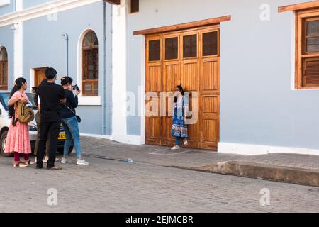 Gruppe von Jugendlichen, die vor einem bunten Haus im französischen Altstadtviertel in Pondicherry, Tamil Nadu, Indien fotografieren Stockfoto