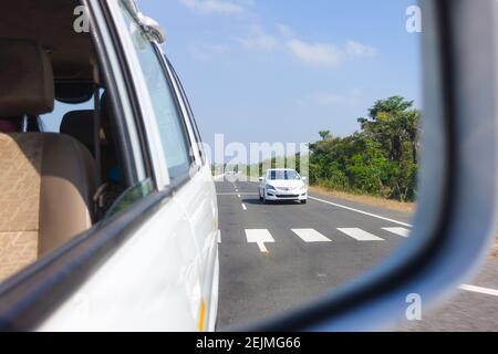 Blick auf Auto und Straße aus einer Seitenansicht Spiegel fahren in East Coast Road, Chennai, Tamil Nadu, Indien Stockfoto