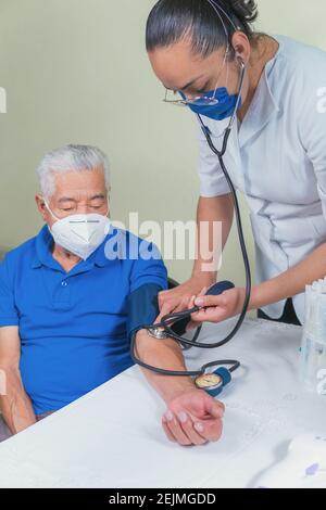 Zeigt, wie der Blutdruck bei einem älteren Mann gemessen wird Stockfoto