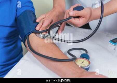 Zeigt, wie der Blutdruck bei einem älteren Mann gemessen wird Stockfoto