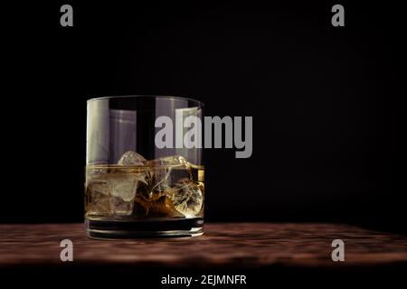 Glas Whiskey mit Eis auf dem Holztisch Stockfoto