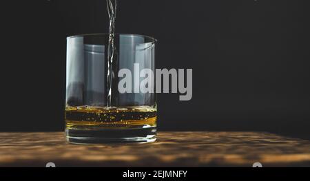 Glas Whiskey mit Eis auf dem Holztisch Stockfoto