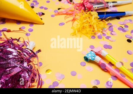 Verschiedene Party-Supplies mit glühenden Konfetti auf dem Tisch verstreut Stockfoto