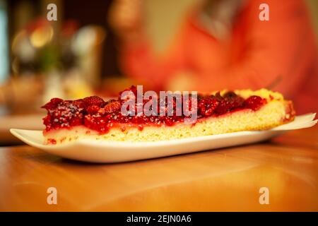 Stück Himbeerkuchen auf einem Holztisch in warm Sommersonne Stockfoto