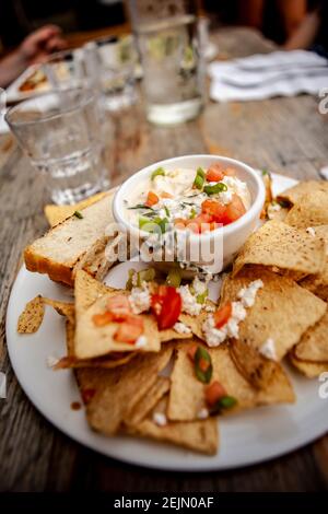 Lecker Quesadilla Dip mit Brot und Chips und frischen Kräutern Und Tomaten Stockfoto