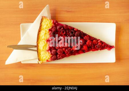 Stück Himbeerkuchen auf einem Holztisch in warm Sommersonne Stockfoto