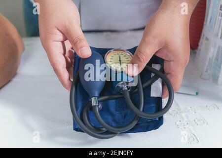 Der Arzt hält in den Händen ein Instrument zur Blutmessung Druck Stockfoto