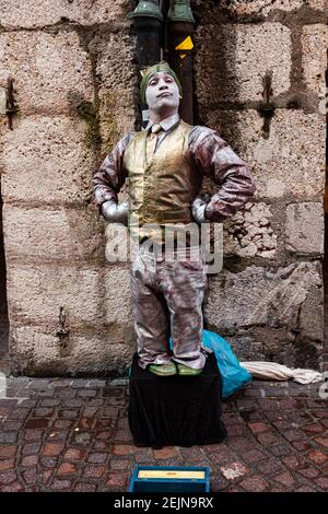 Salzburg, Österreich, 01,11.2013. Eine lebende Statue von Straßenkünstler mit silberner Farbe bedeckt zeigt einen Zwergharlekin Stockfoto