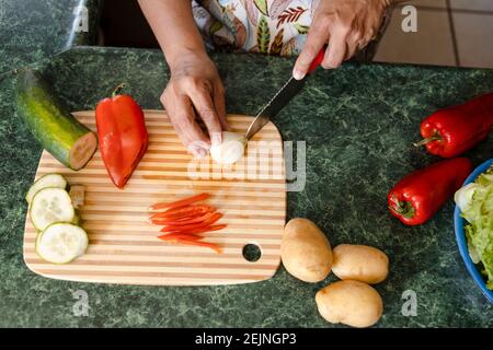 Draufsicht Frauenhände Kochen gesunde Lebensmittel - Zutaten zu Machen Sie frische und organische Salate - Mama schneiden Gemüse in Ihre Küche Stockfoto