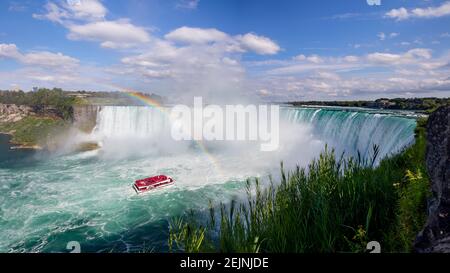 Touristenkreuzfahrt Schiff unter Regenbogen auf dem Niagara River Besuch der Wasserfälle an einem sonnigen Sommertag Hornblower Und Maid of the Mist Boats Tour Stockfoto