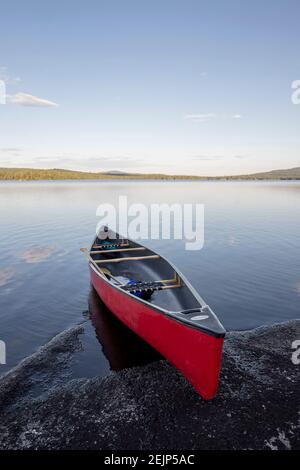 Rote Kanu zog auf felsigen Ufer der unberührten Ruhe see in Maine Stockfoto