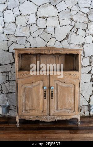 Hölzerner alter kleiner leerer Schrank über einer Steinwand Stockfoto