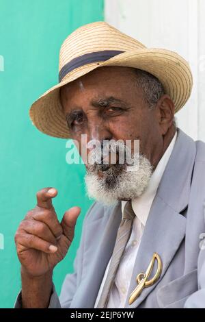 Ein älterer, gut gekleideter Mann raucht in Trinidad, Kuba, eine kubanische Zigarre Stockfoto