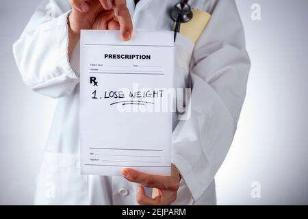 Eine kaukasische Ärztin im weißen Mantel verschreibt einem übergewichtigen oder übergewichtigen Patienten in ihrem Büro Gewicht zu verlieren. Ein Konzeptbild für Lifestyle m Stockfoto