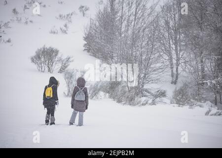 Pärchen, die durch schneebedecktes Feld laufen Stockfoto