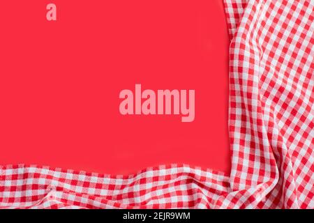 Rot karierte Tischdecke auf rotem Hintergrund. Draufsicht mit Kopierbereich Stockfoto