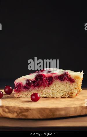 Hausgemachter Kuchen mit Preiselbeeren und saurer Sahne. Stück Kuchen Nahaufnahme. Vertikales Bild. Stockfoto