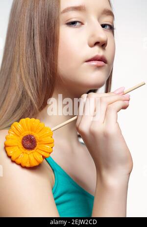 Teenager Mädchen mit Blume Lollipop in den Händen. Naschkatzen-Konzept. Stockfoto