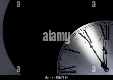 Vintage Wanduhr mit römischen Ziffern, die fünf Minuten bis anzeigen Mitternacht als Symbol für die Zeit, die knapp wird Stockfoto