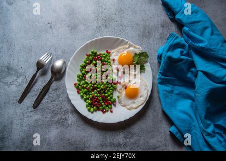 Pochierte Eier und frisch gedünstetes Gemüse auf einem Teller. Stockfoto