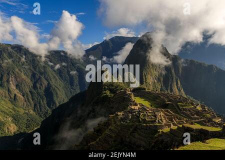 Panoramablick über die alte Inka-Tempelstadt Machu Picchu umgeben von einer Gruppe von Wolken Stockfoto