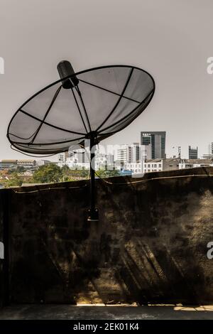 Schwarzer Satellitenantenne Empfänger am Balkonhaus mit Blick auf die Stadt. Kein Fokus, speziell. Stockfoto
