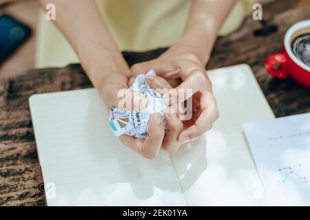 Eine Geschäftsfrau zerknüllte Papiere von Hand. Scheitern, schlecht, keine Idee Konzept. Stockfoto