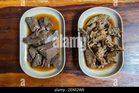 Entenblutgelee und gekochte Entenflügel Einkochen in Sojasauce auf Holztisch. Vorspeise, selektiver Fokus. Stockfoto