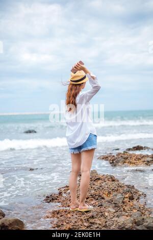 Frau wirft Handy in den Strand. Stockfoto