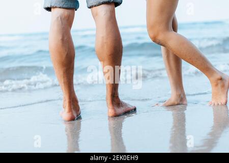 Die Beine des Paares stehen zusammen am Strand. Mann und Frau in der Liebe. Stockfoto