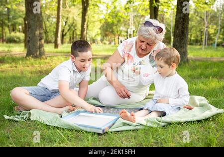Glückliche Momente mit Großmutter. Großmutter spielt mit Enkeln Stockfoto