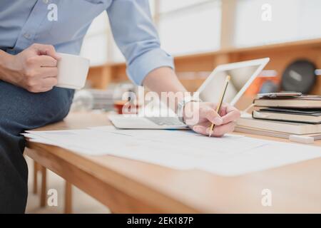 Geschäftsmann mit Bleistift Überprüfung Dokument-Daten-Rechner zur Berechnung Budget Buchhaltung. Finanz-und Rechnungswesen Konzept Stockfoto