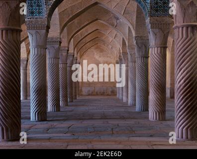 Symmetrische Spiralsäulen in einer Halle der Vakil Moschee in Shiraz, Iran. Wunderschönes symmetrisches Design. Stockfoto