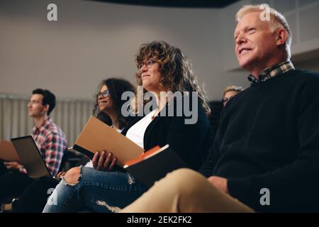 Gruppe multiethnischer Geschäftsleute, die in einem Forum sitzen. Geschäftsleute, die an einem Firmenseminar teilnehmen. Stockfoto